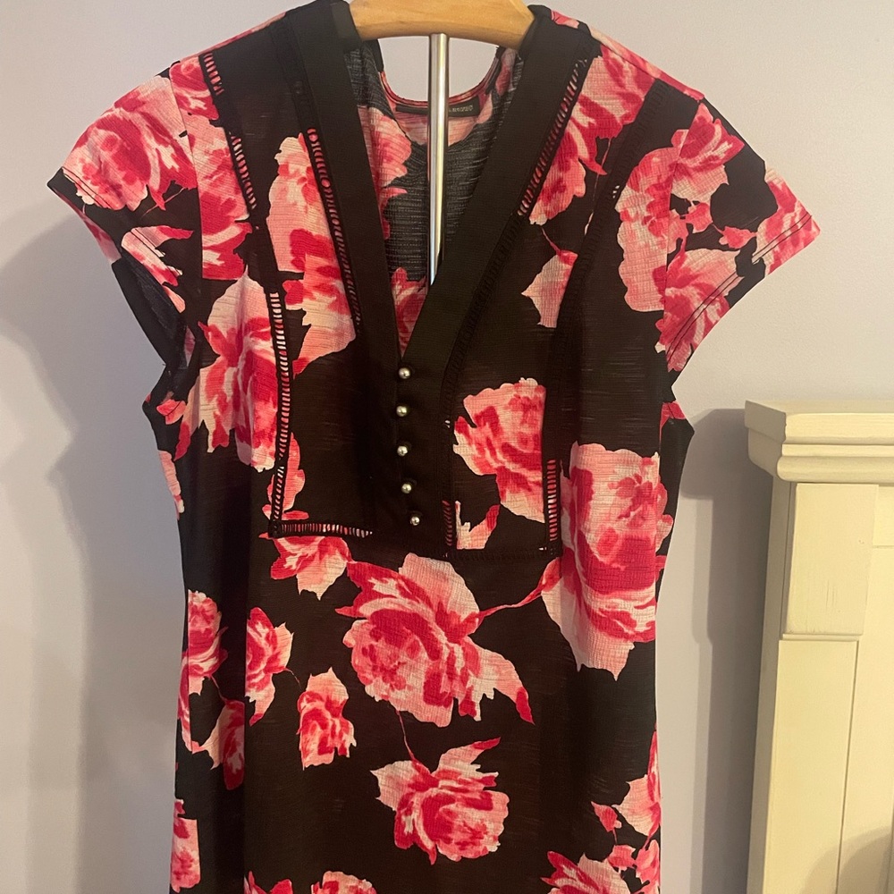 Black top with hot pink flowers, and a row of five petite silver buttons.